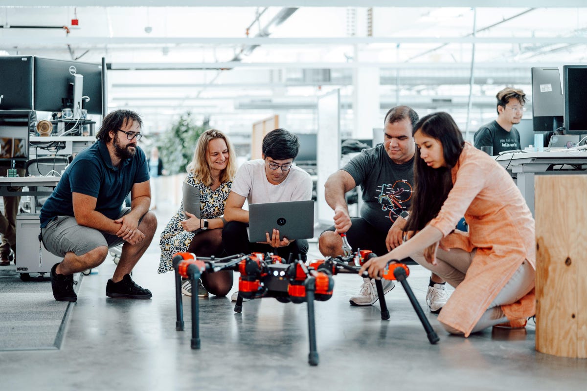 Facebook AI researchers in Menlo Park with Daisy, a hexapod robot learning to walk. From left: Roberto Calandra, research scientist; Franziska Meier, research scientist; Yixin Lin, research engineer; Omry Yadan, software engineer; Akshara Rai, research scientist.