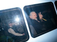 <p>Julian Assange gestures to the media from a police vehicle on his arrival at Westminster Magistrates court on Thursday in London.</p>