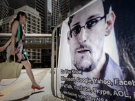A woman walks past a banner displayed in support of ex-NSA analyst Edward Snowden in Hong Kong on June 18, 2013.