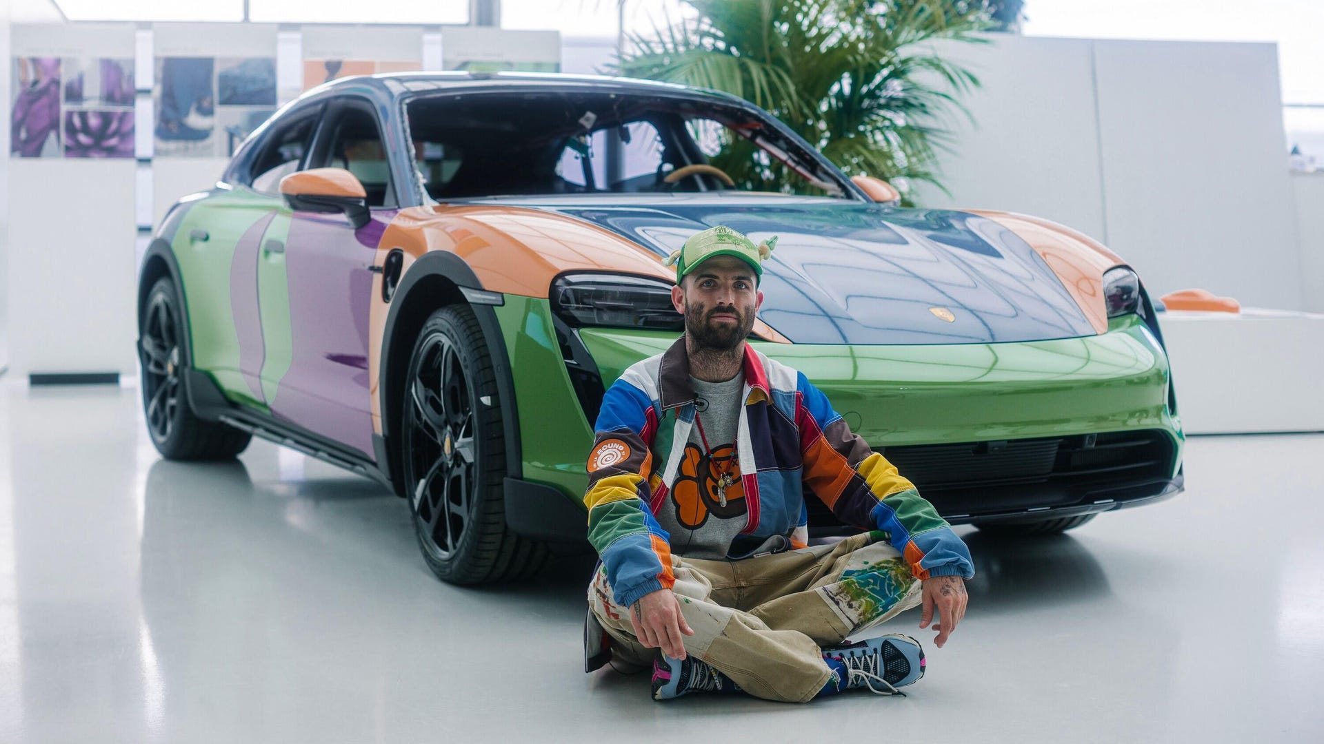 Porsche Taycan Cross Turismo art car with artist sitting in front of it