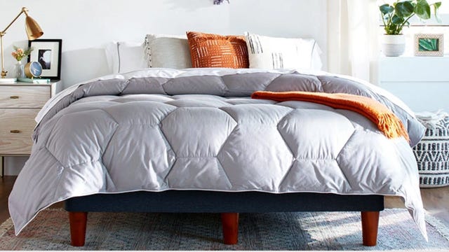 A bed made with a Layla Down Alternative comforter with a nightstand next to it.