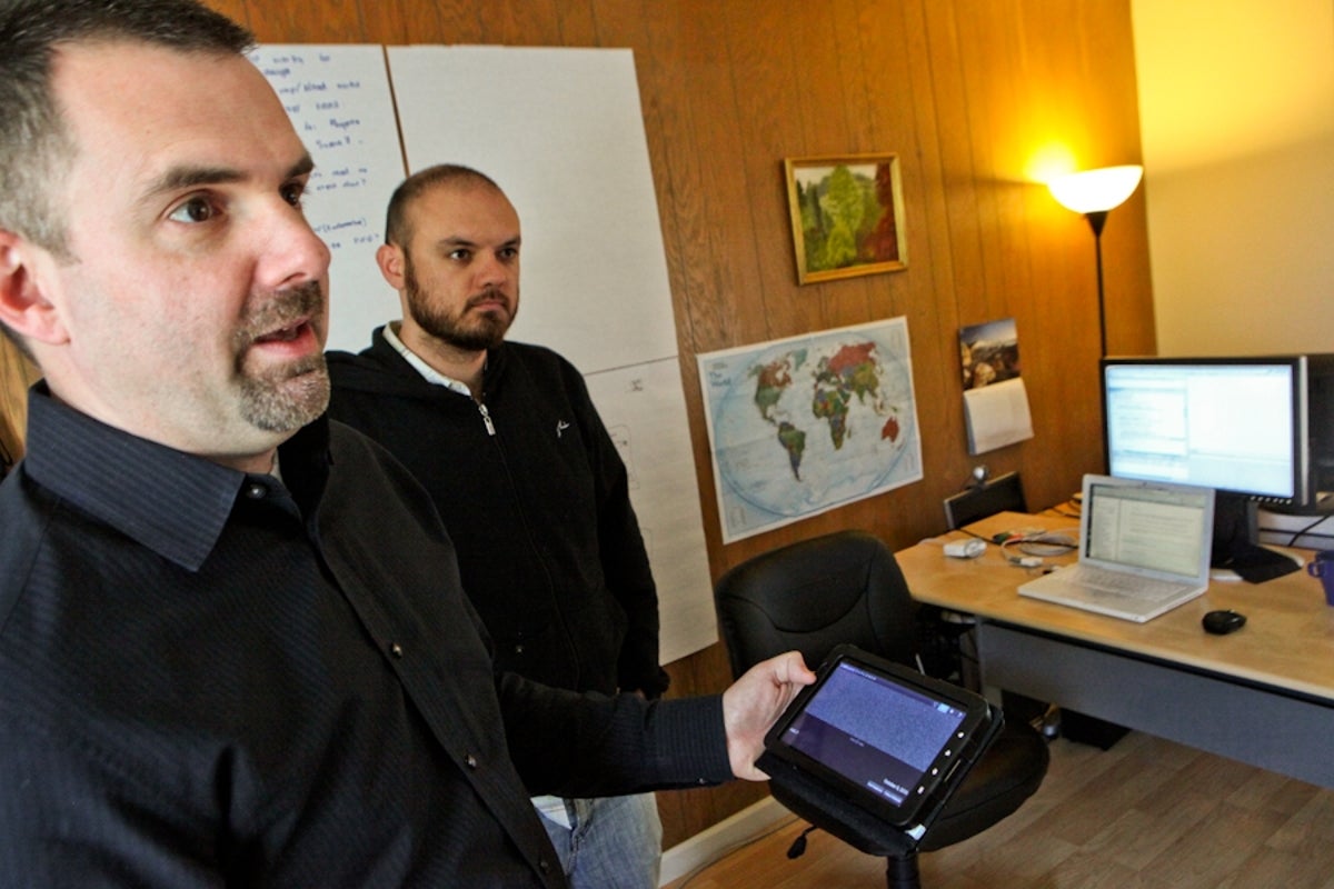 Francis Potter, founder and chief executive of The Hathersage Group, shows off the setiQuest Explorer mobile app he developed. Blake Barrett, application architect at the firm, (at right) helped him on the project.