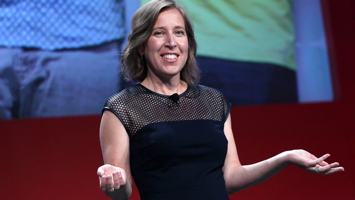 YouTube CEO Susan Wojcicki holds out her arms at an on-stage presentation