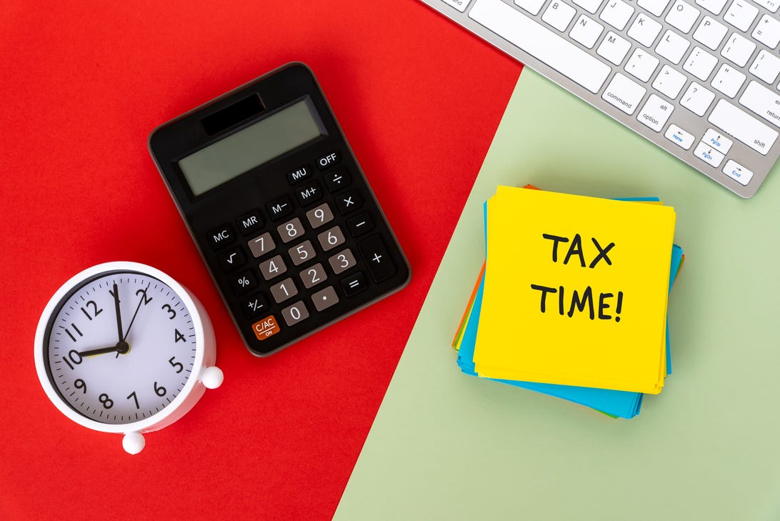 A clock, a calculator, a keyboard and a note that says TAX TIME!