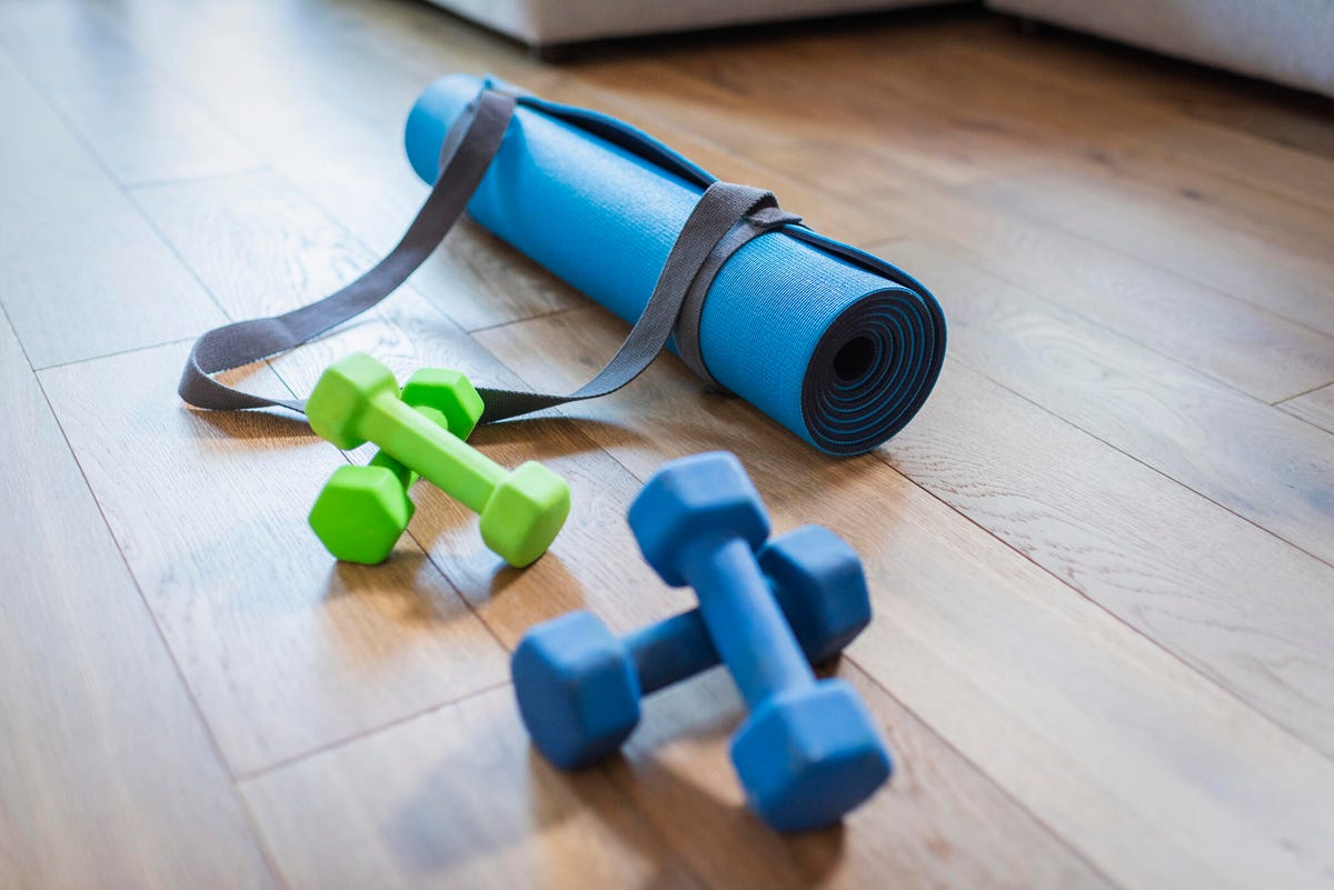 Two sets of dumbbells and a yoga mat