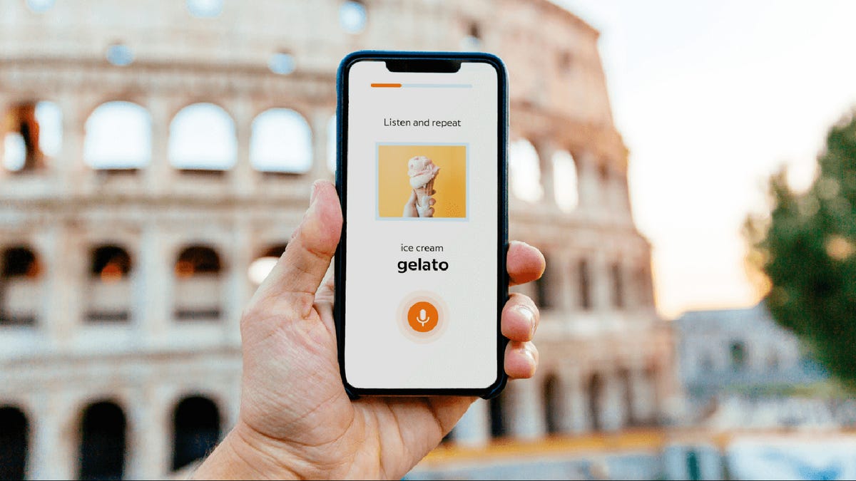 Someone holding up a phone in front of the Colosseum, the screen displays the translation for "ice cream"