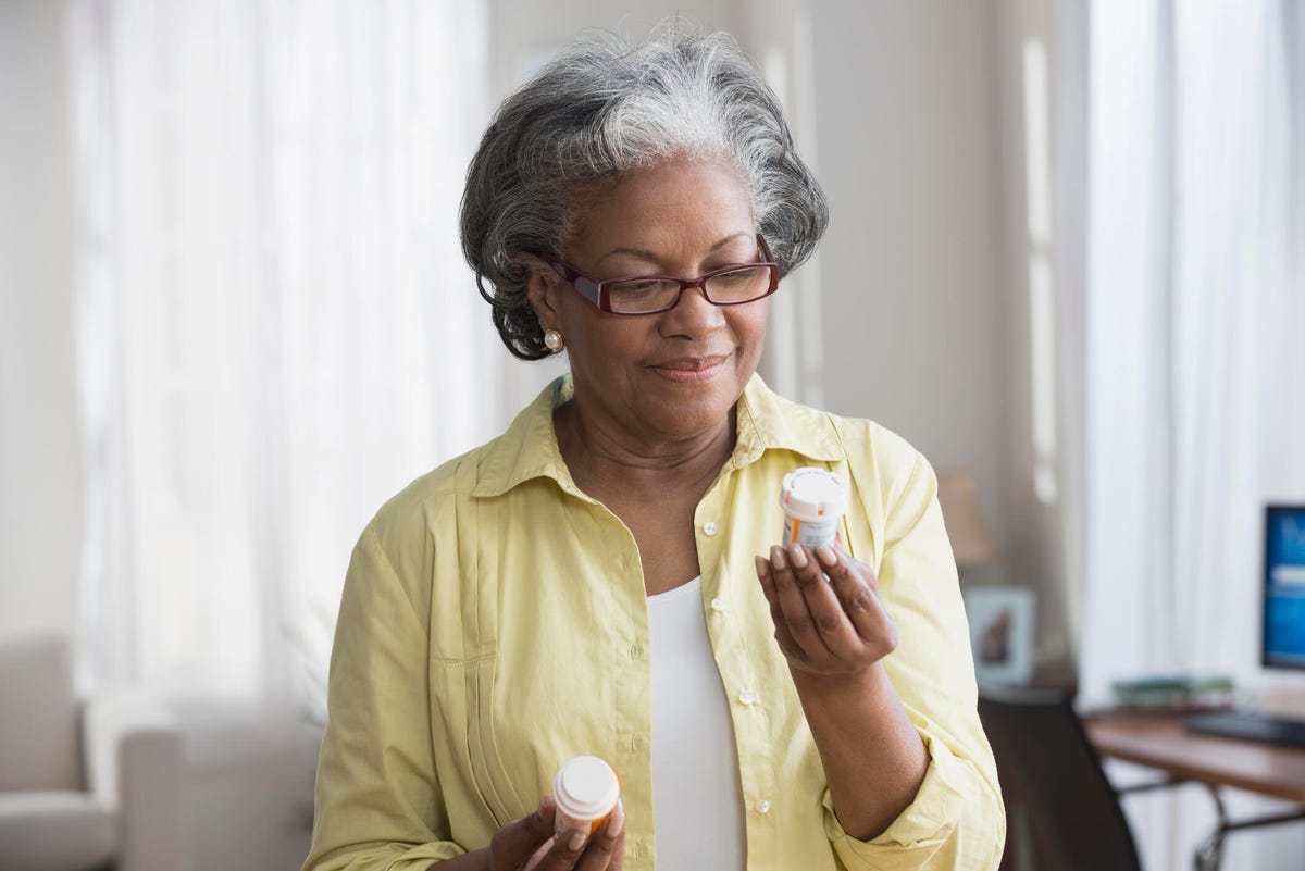 A senior looking at a bottle of pills