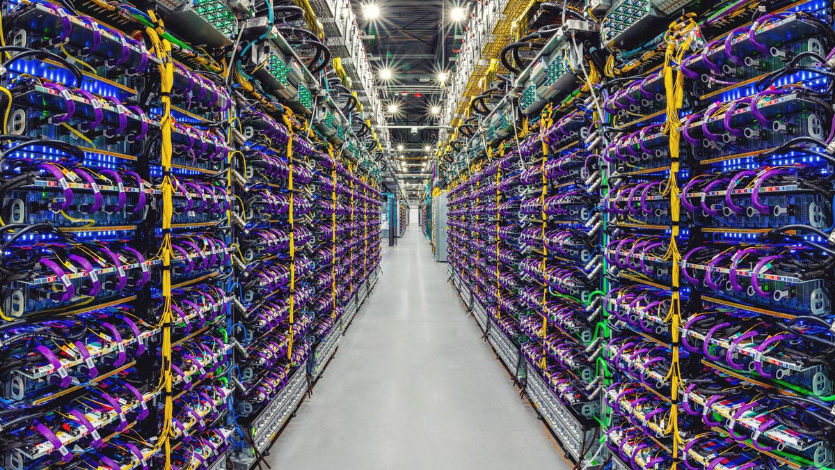 A data center photo shows racks with hundreds of servers linked with purple, green and yellow cables. The view looks down a long aisle showing the massive scale of Google's computing infrastructure.