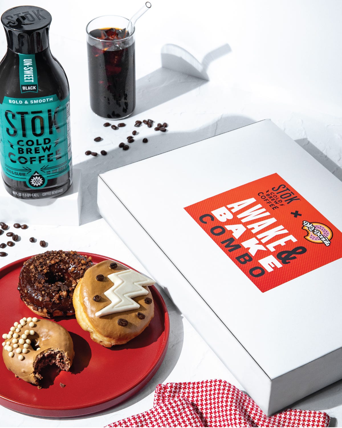 A bottle of STōK cold brew coffee and a box of DK's Donuts
