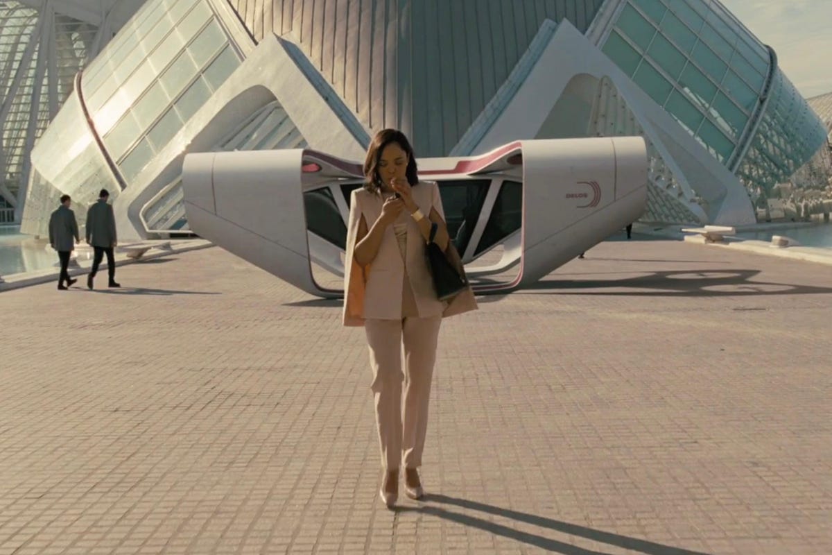Tessa Thompson stands in front of a large futuristic building