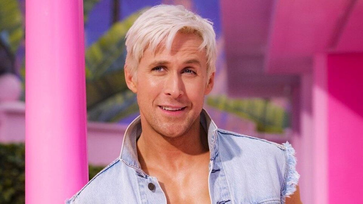 A blond Ryan Gosling as Ken, leaning against a pink column.
