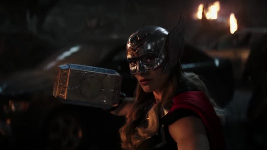 Natalie Portman wearing helmet, armor and carrying a magic hammer in Thor: Love and Thunder.