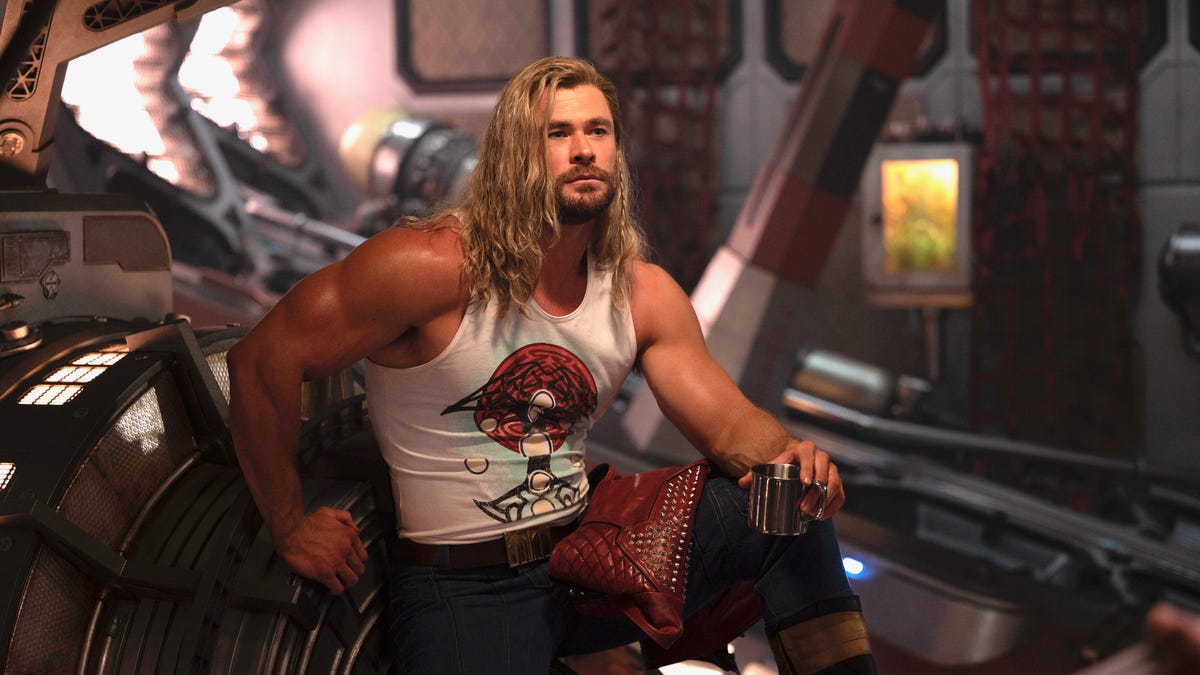 A buff Chris Hemsworth, as Thor, kicks back in a tank top.
