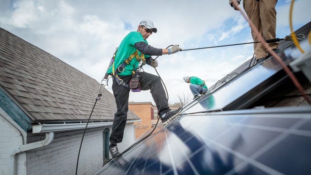 A solar panel installer working on a roof.