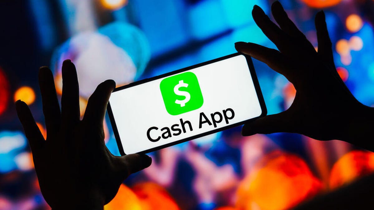 A person's hands holding a phone that displays the "cash app" symbol
