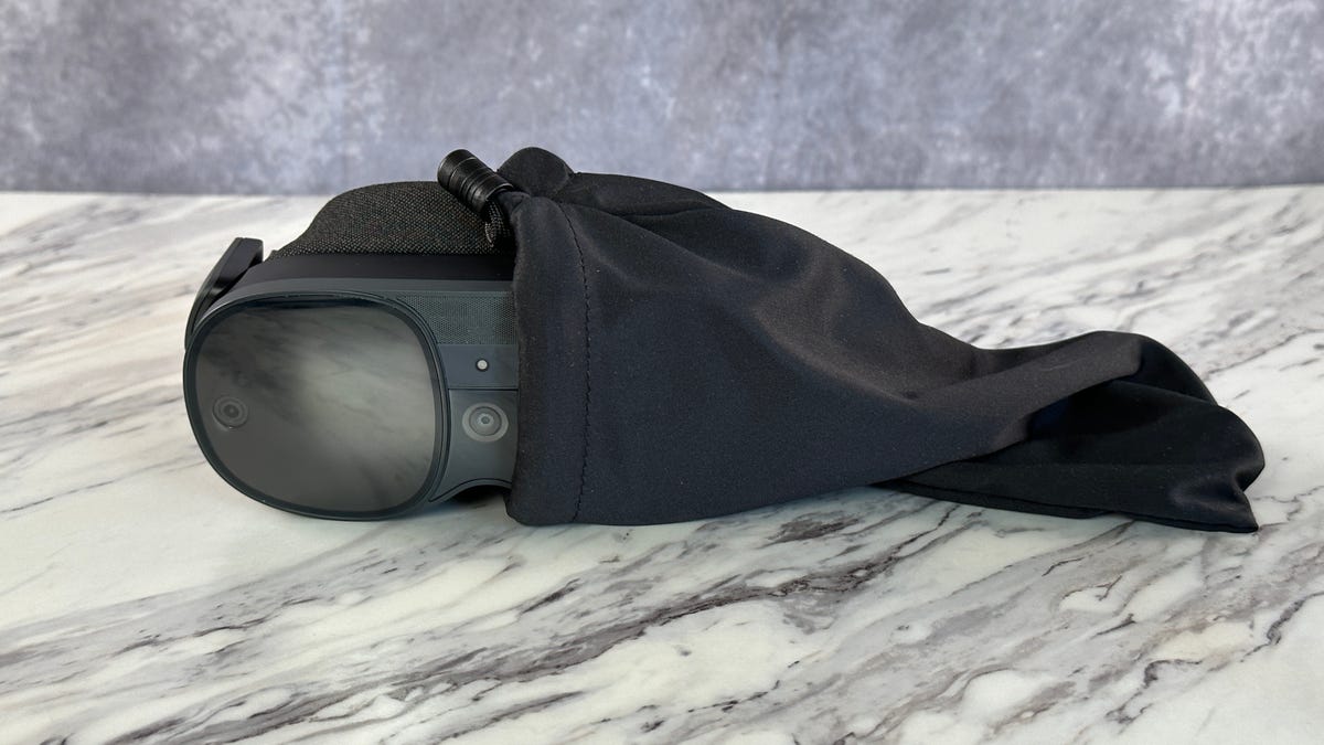 A pair of VR glasses emerging from a black bag, resting on a white table