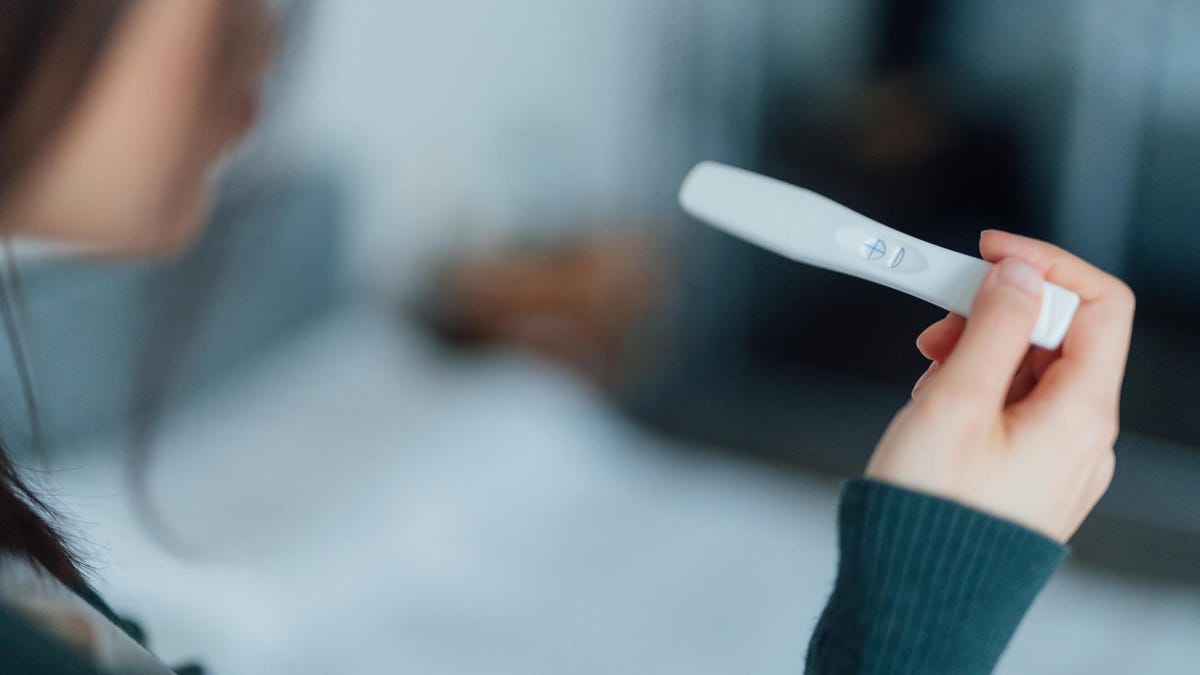 A woman holds a pregnancy test in her hand