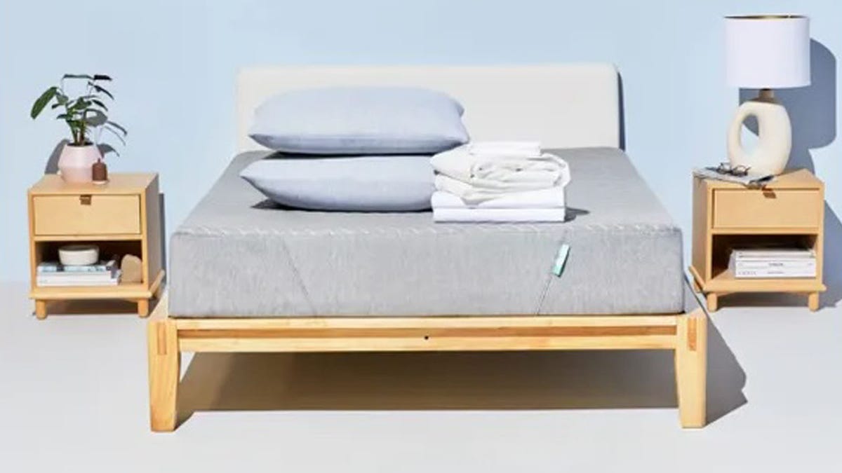 The Siena Sleep memory foam mattress rests on a base near two nightstands.