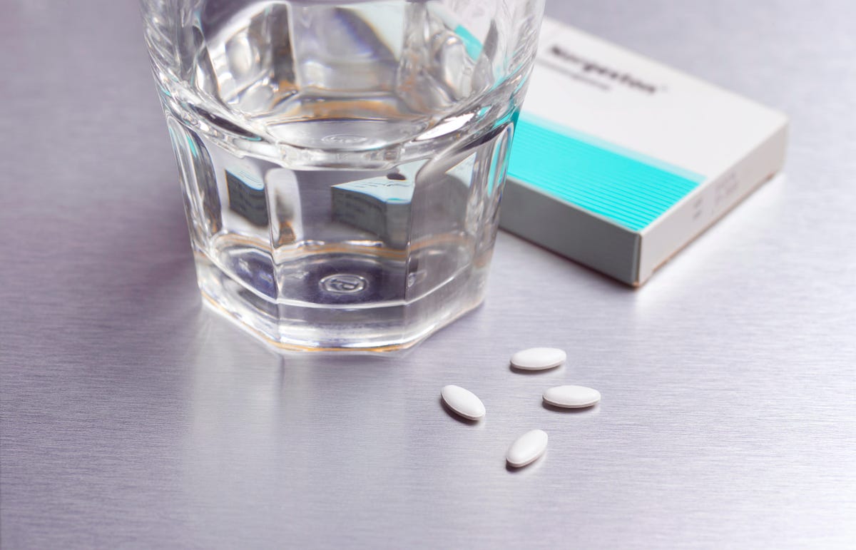A glass of water sits next to abortion medication
