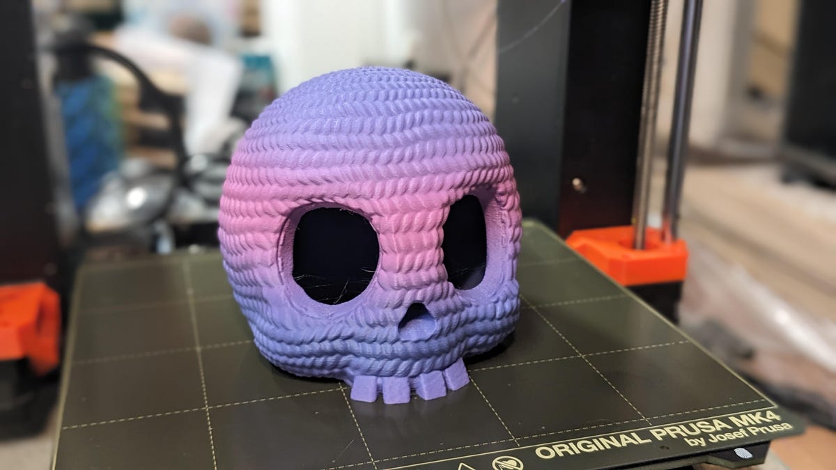 A skull that looks like it's made of pink to purple crochet