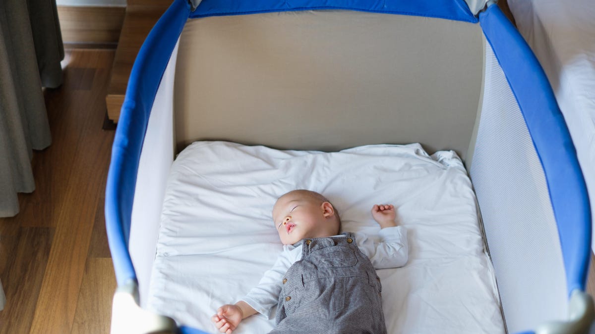 A baby sleeping in a playpen