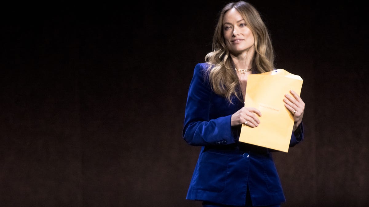 Director and actress Olivia Wilde holds a mysterious envelope onstage.