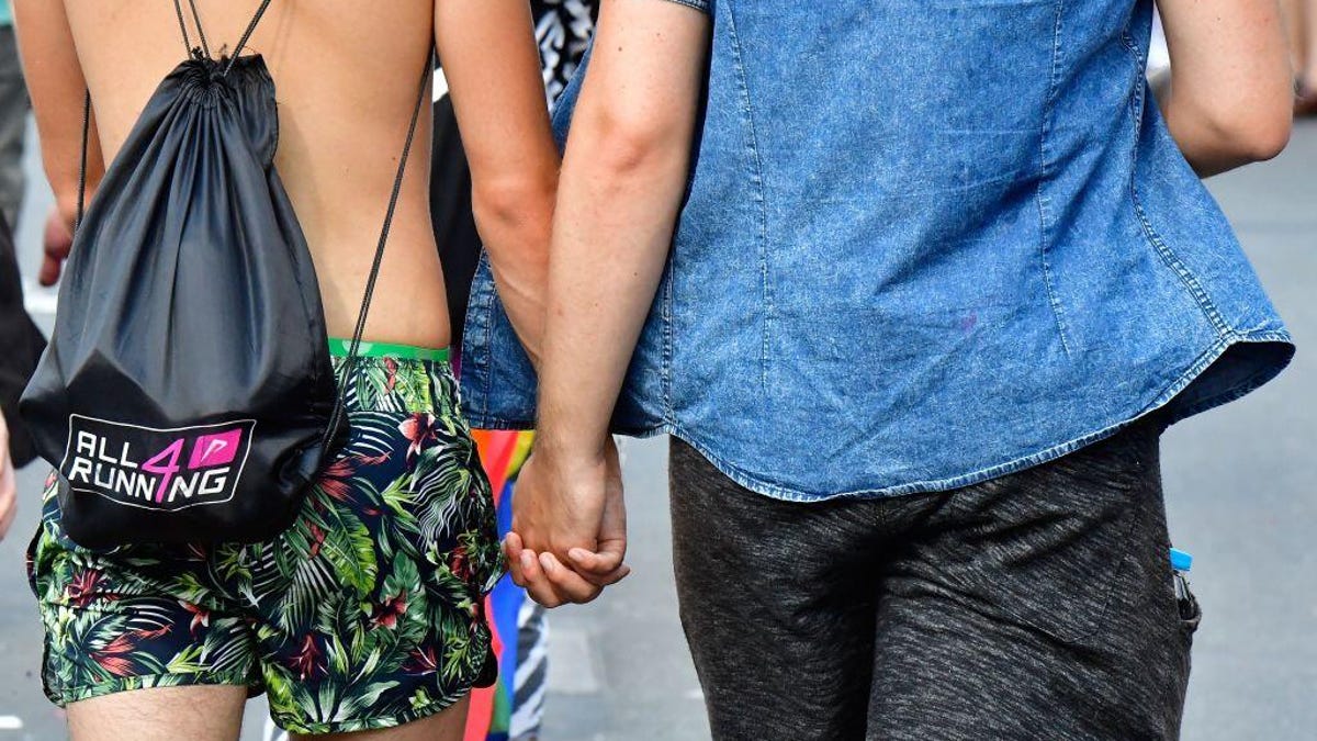 A gay couple holds hands