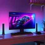 A monitor backlit by purple and blue lights