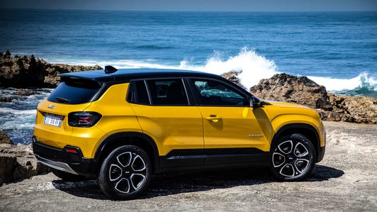 Rear 33/4 view of the 2023 Jeep Avenger EV on a rocky shore