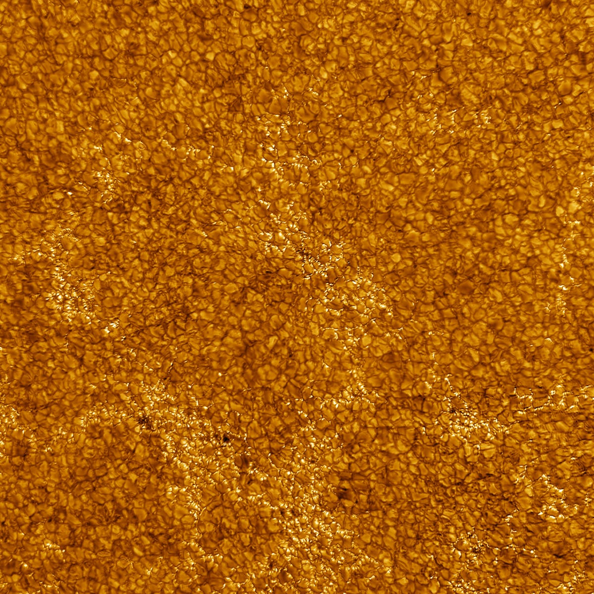 Orange and dark orange pebbly-looking view of the surface of the sun.