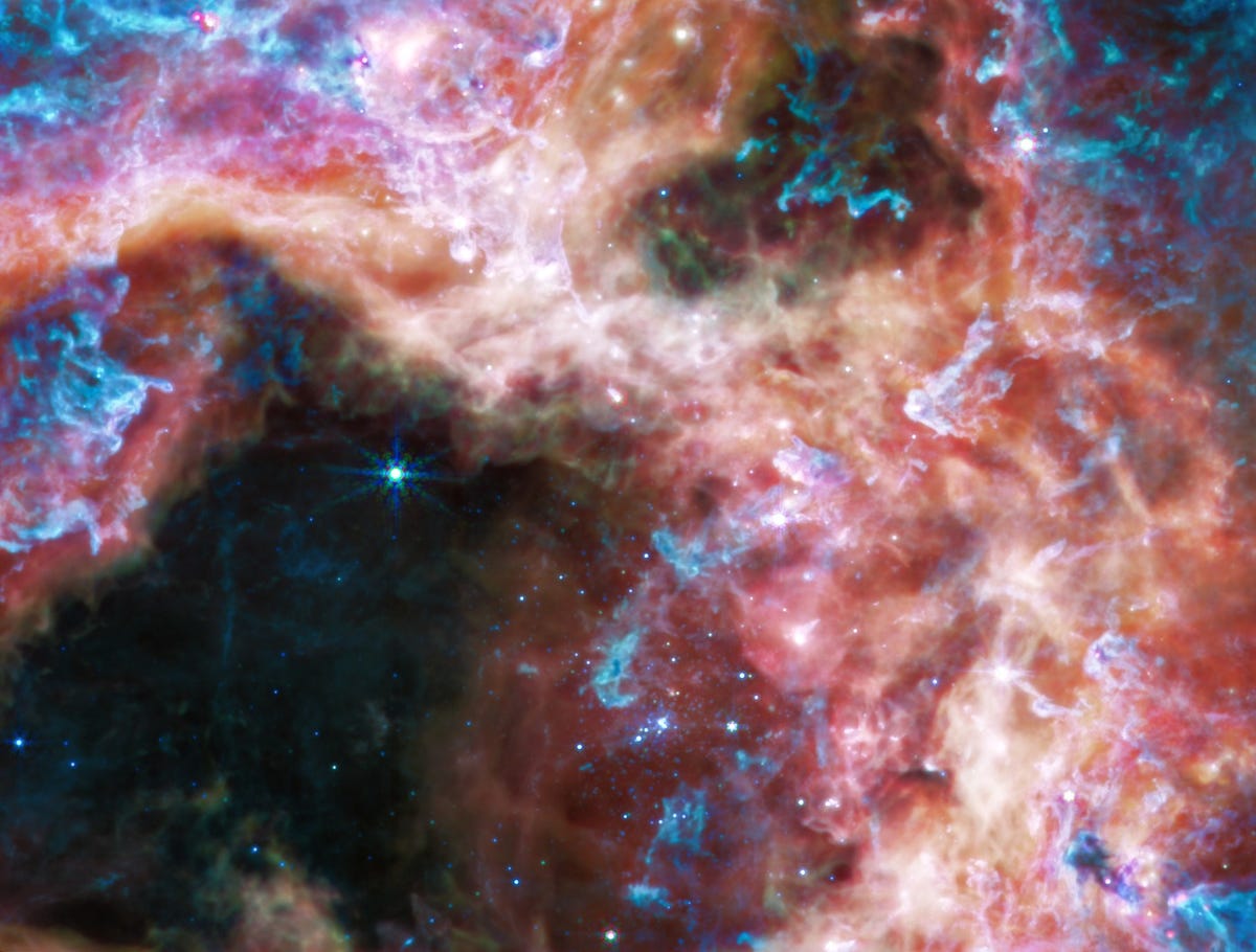 Shades of red, blue and purple swirl as the gas and dust of the Tarantula Nebula are highlighted.