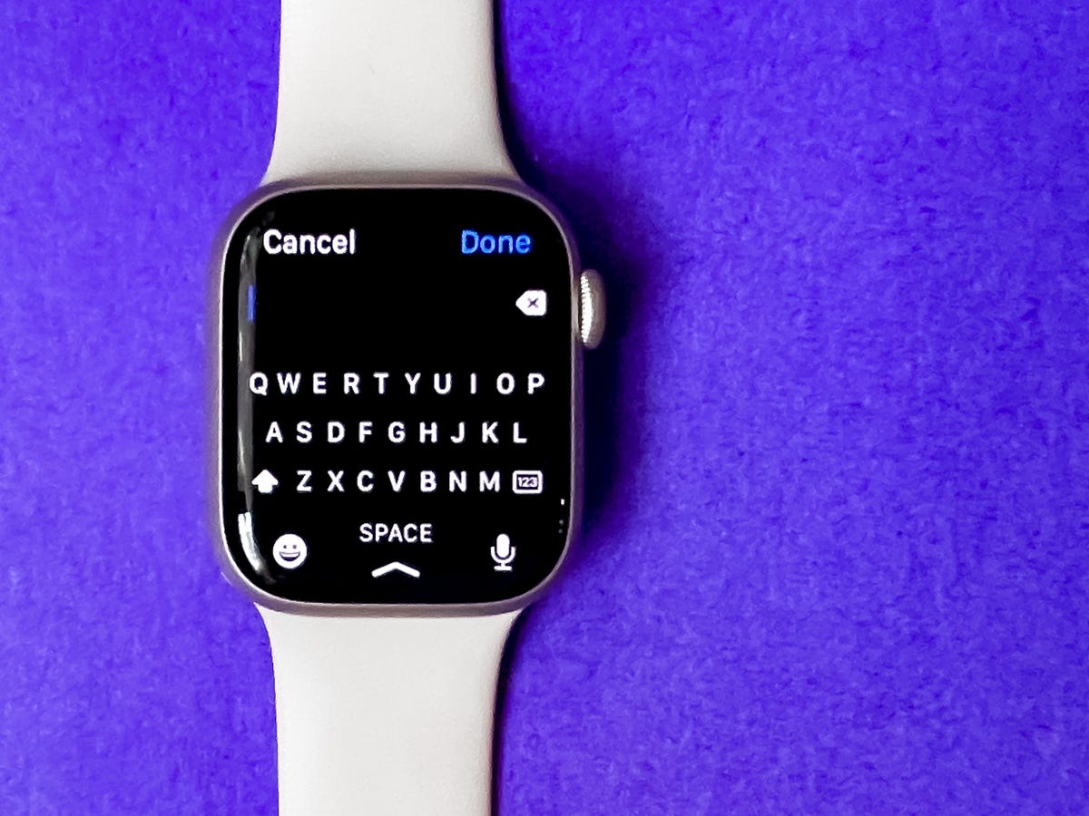 The Apple Watch Series 7 with its keyboard on screen against a purple background