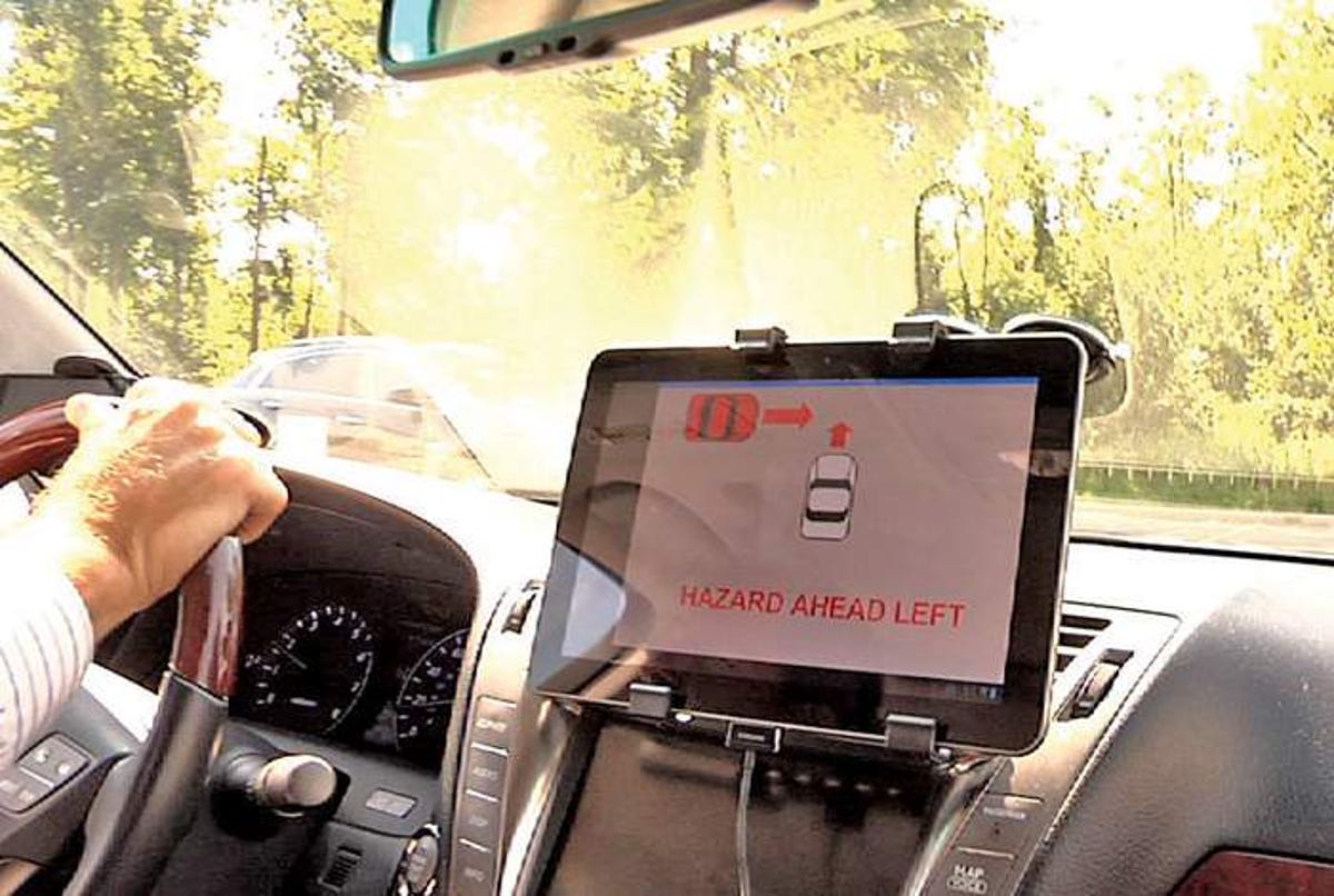 A video screen warns a driver of a potential collision ahead during a demonstration by Denso International America.