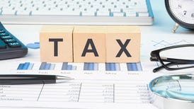 tax documents, a keyboard, spreadsheets, and other items on a desk