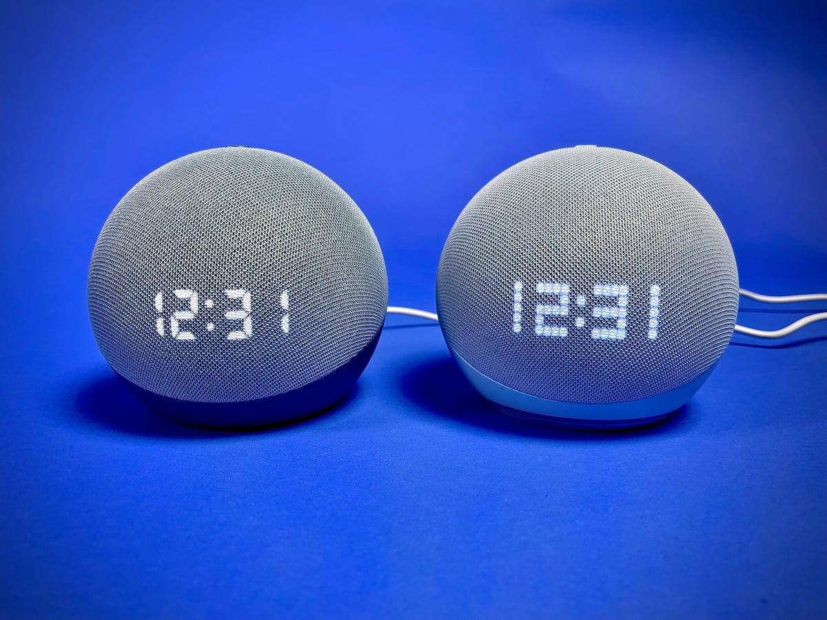 The 4th- and 5th-gen Amazon Echo Dot with Clock smart speakers sitting side by side against a blue background.