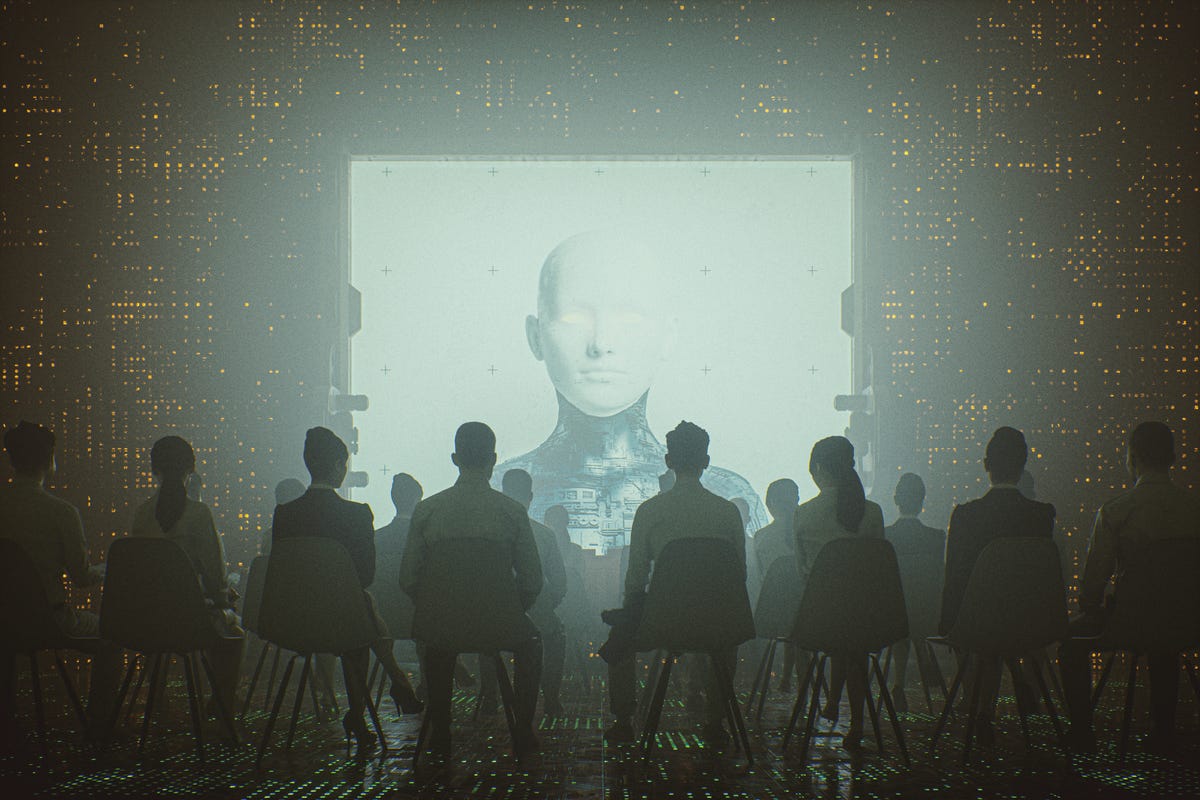 A vaguely dystopian image shows people from behind, in silhouette, sitting and facing a giant glowing screen on which is displayed a pure white face atop a body that seems to be made of computer circuitry.