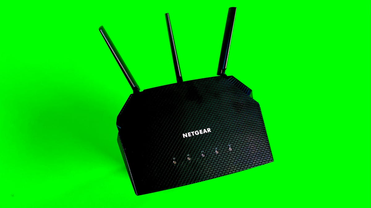 The Netgear R6700AX Wi-Fi 6 router sitting atop a green backgrop.