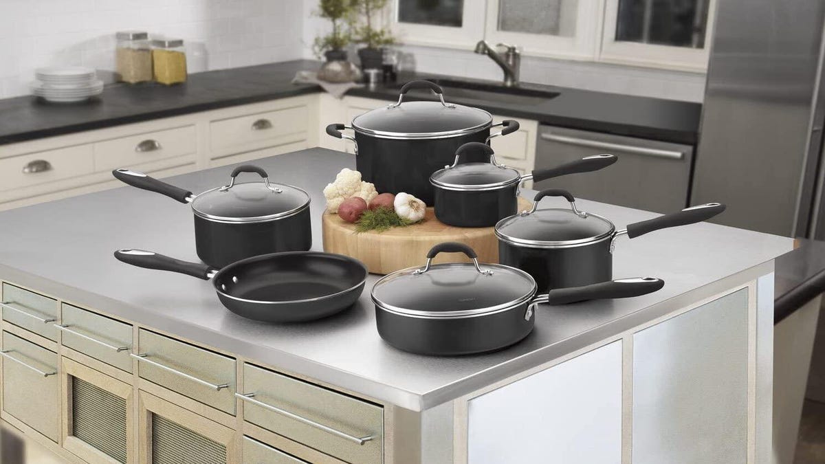 A set of black pots and pans on a kitchen counter.
