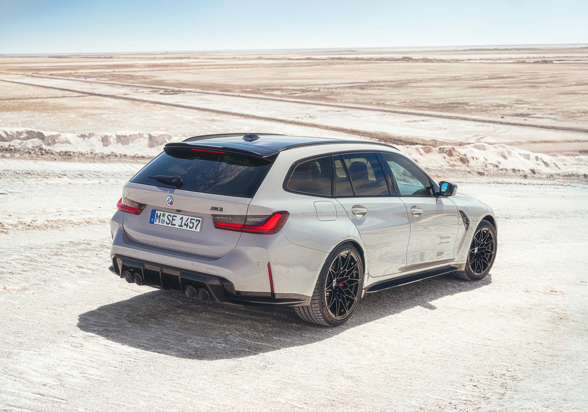 Rear 3/4 view of a gray BMW M3 Touring wagon in the desert