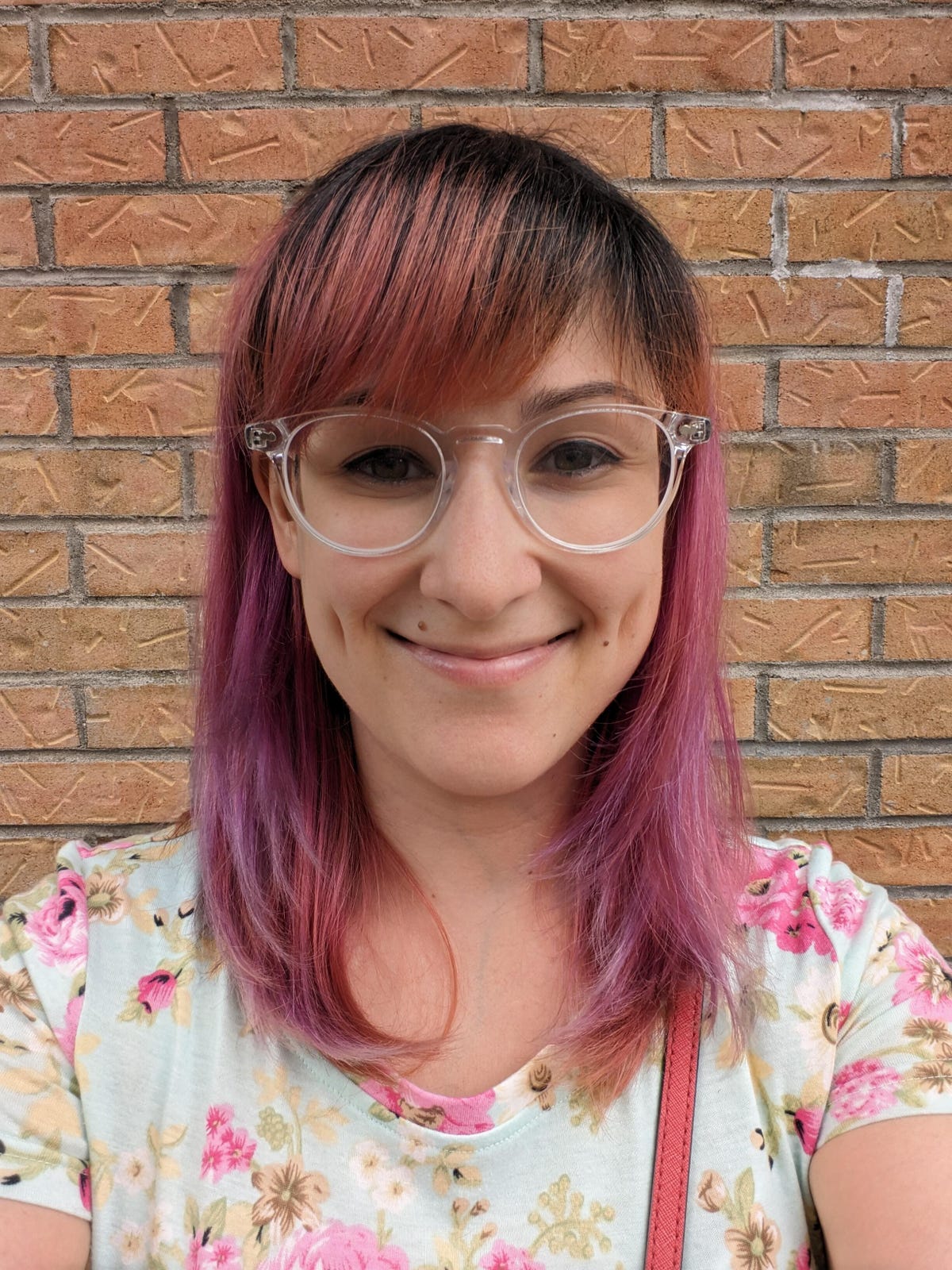 A selfie showing a woman in front of a brick wall taken on the Pixel Fold