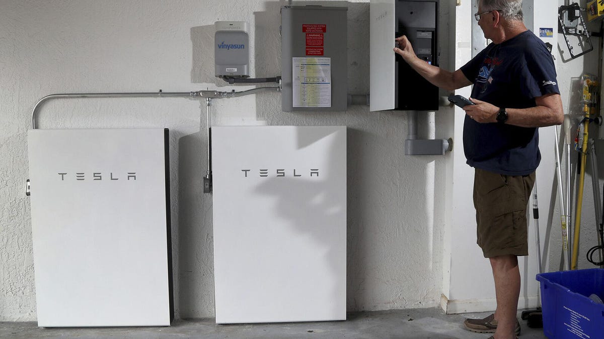 A man checking on his Tesla Powerwall home battery back up system