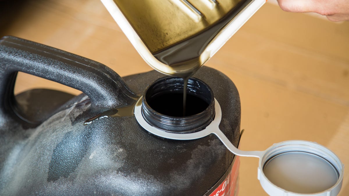 oil is poured from a pan into a bottle