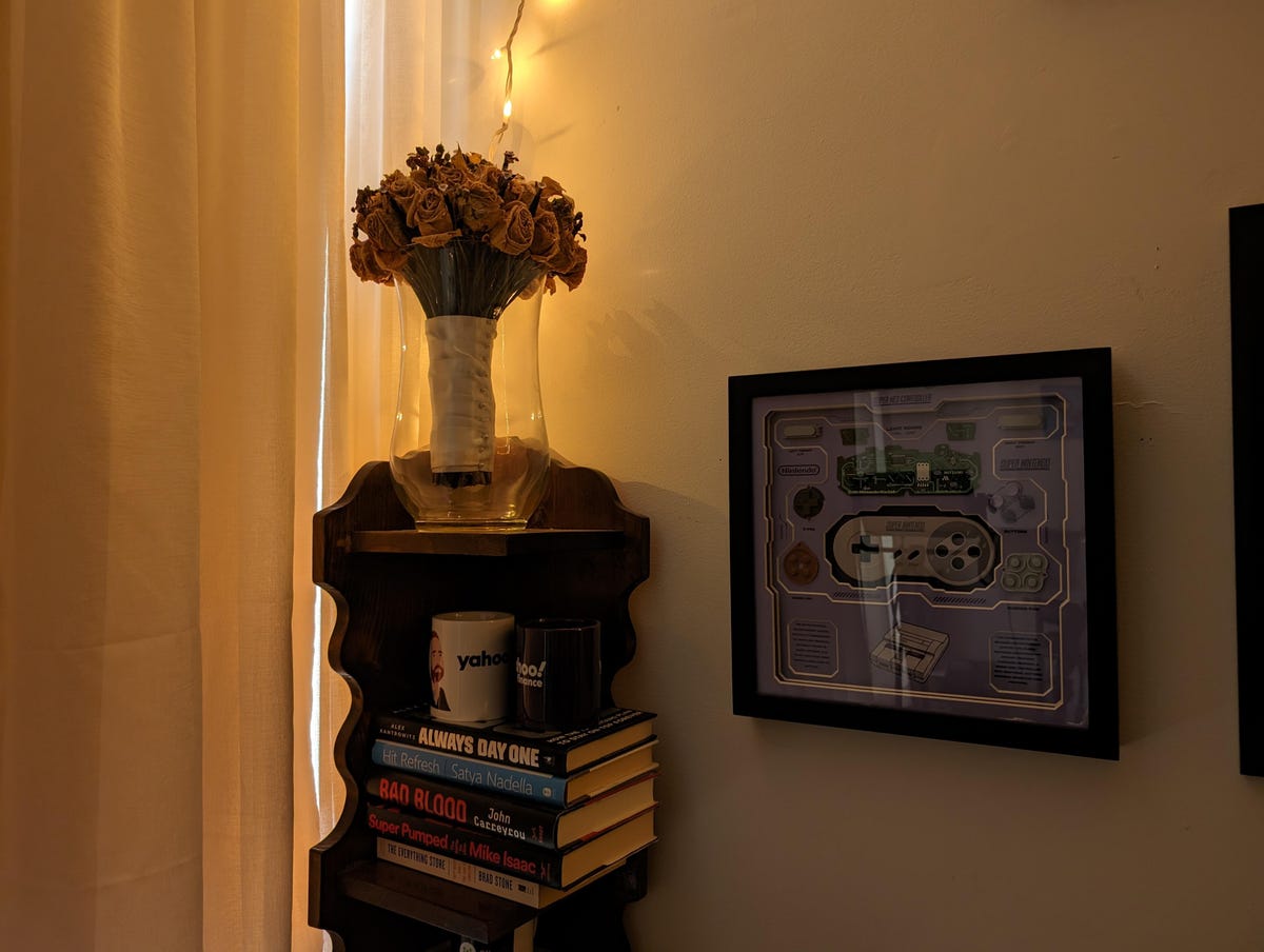 A photo of a bookshelf taken on the Pixel 8 Pro in dim lighting.