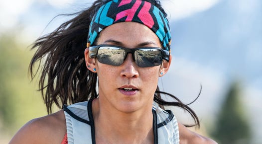 A woman running while wearing a pair of Bose Frames Tempo