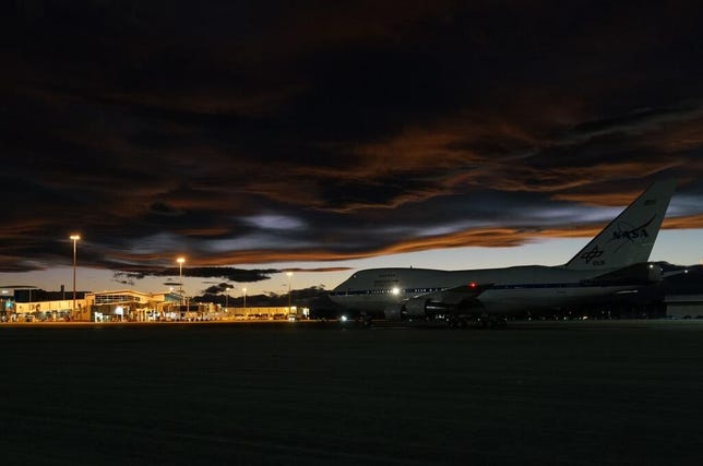 Boeing 747SP SOFIA parked on a darkening night with low clouds in New Zealand.