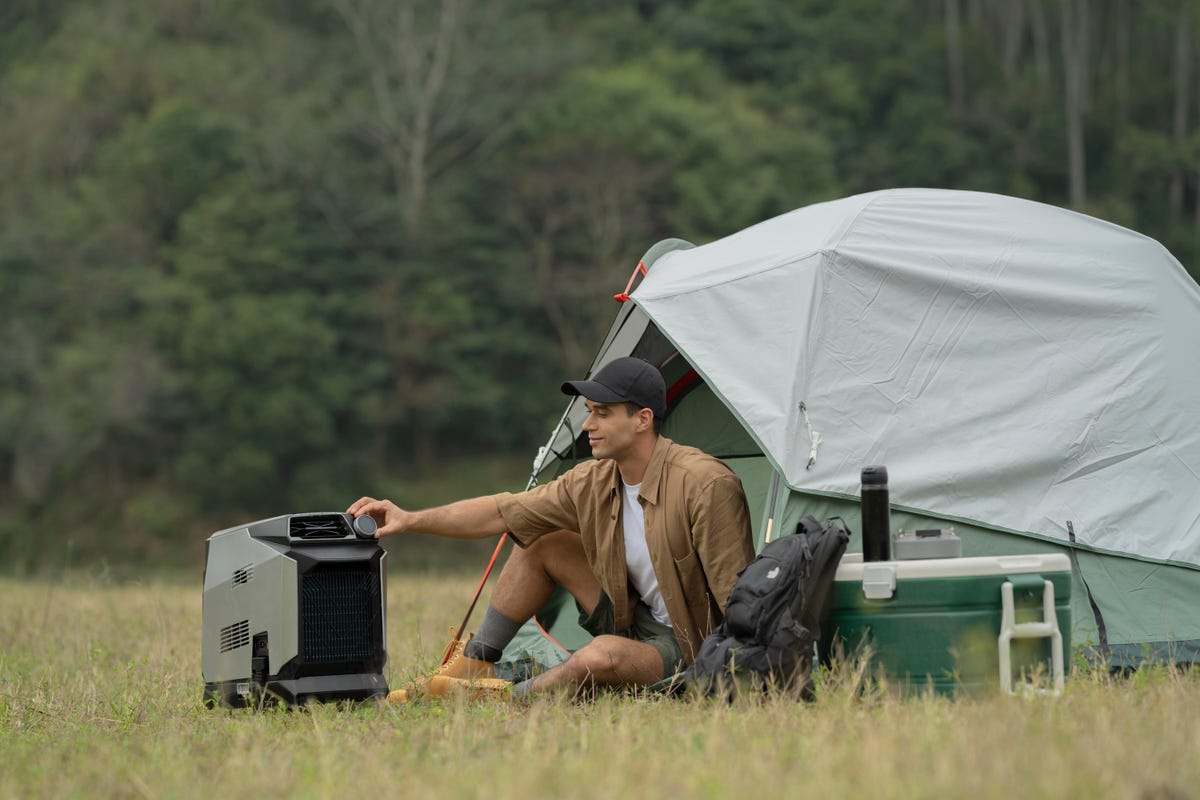 EcoFlow Wave Portable Air Conditioner shown cooling a person sitting in front of an open tent