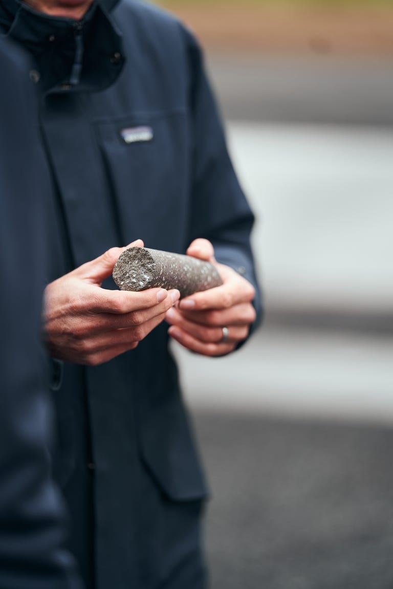 A man holds a cylindrical chunk of mineralized carbon