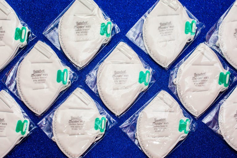 A photo of N95 face masks wrapped in plastic on a blue background