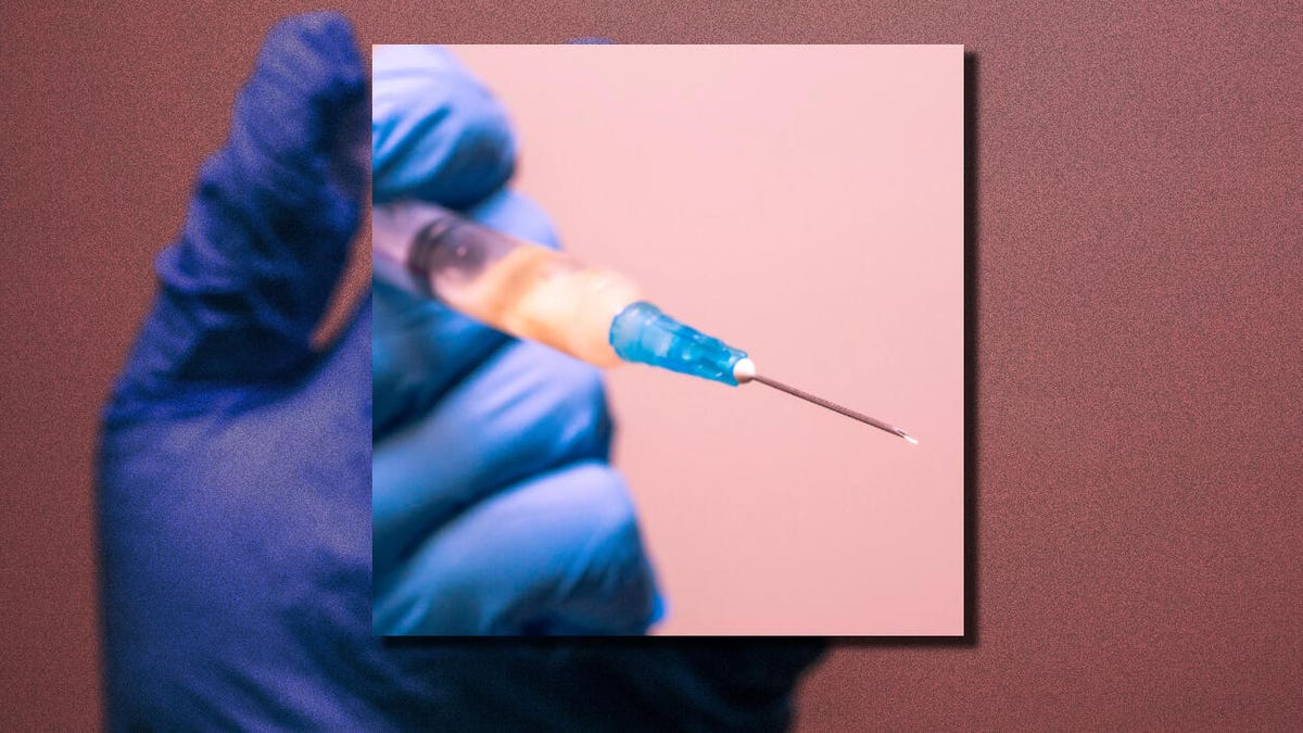 Hypodermic needle in a gloved hand