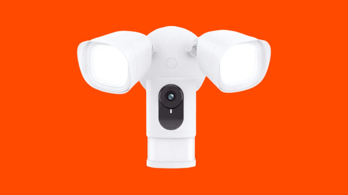 A white Eufy floodlight camera against an orange background.